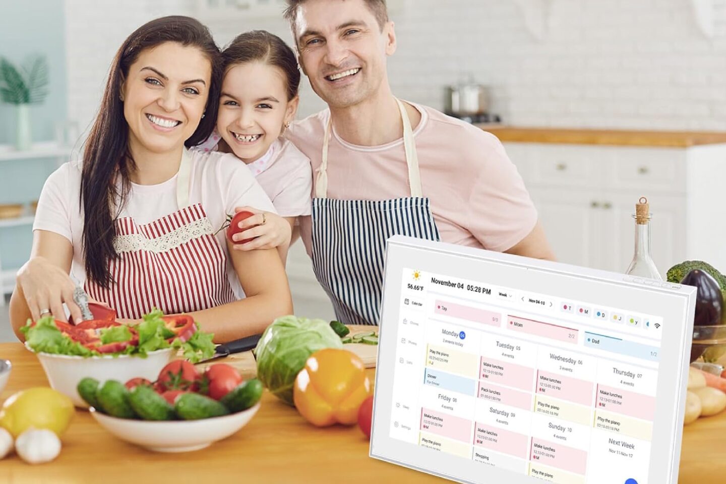 Photo of a family in a kitchen using a digital calendar and chore chart.