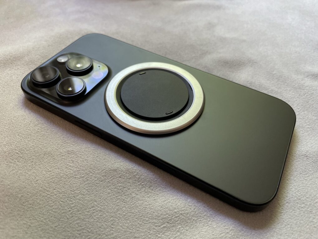 Black iPhone 16 Pro with the Ohsnap Snap 4 Luxe on the back, sitting on a gray microfiber cloth.