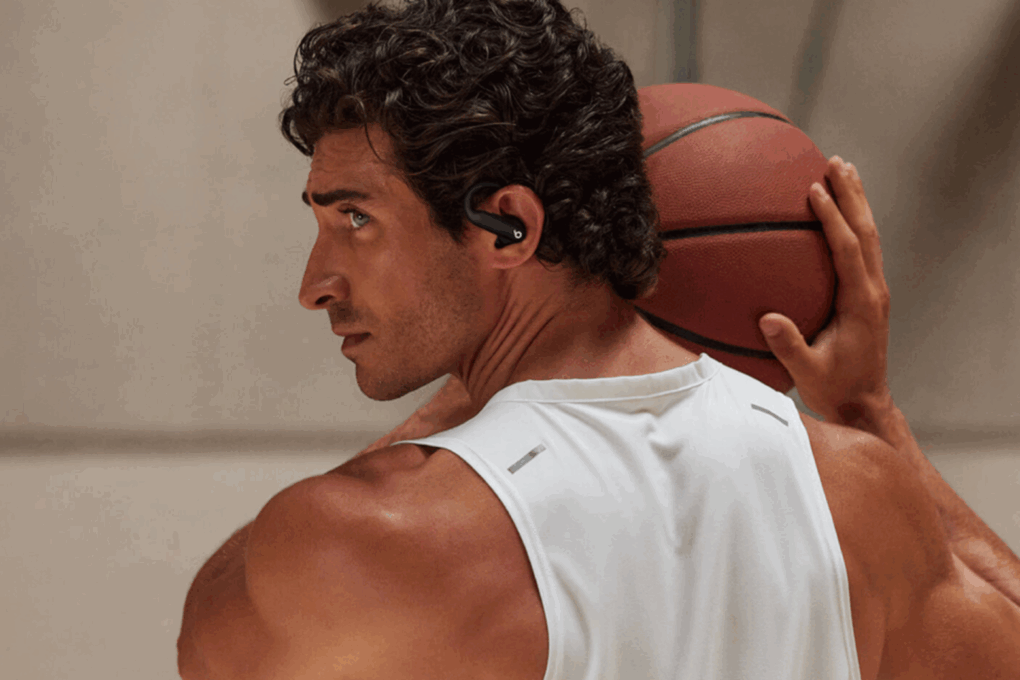 Man holding a basketball while wearing Beats Powerbeats Pro 2 wireless earbuds, used to illustrate a deal on refurbished models.