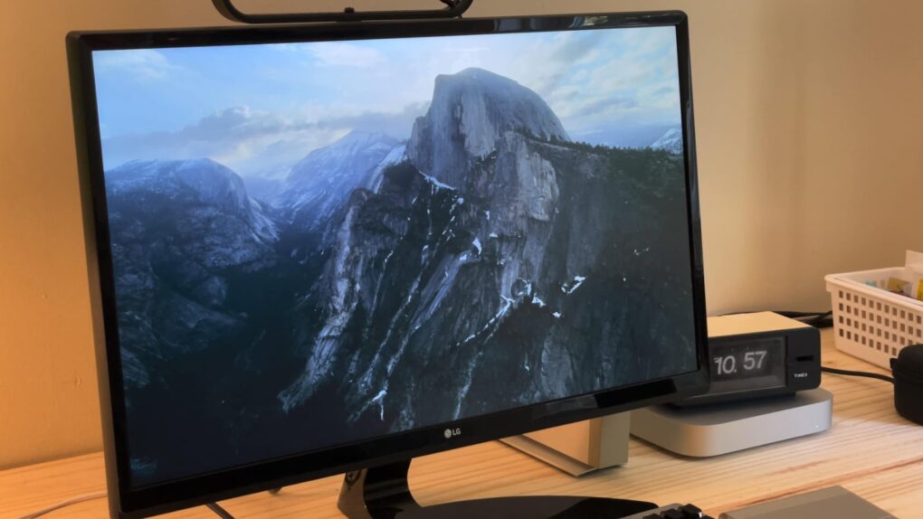 Photo of a Mac with an Aerial screen saver showing rugged mountains