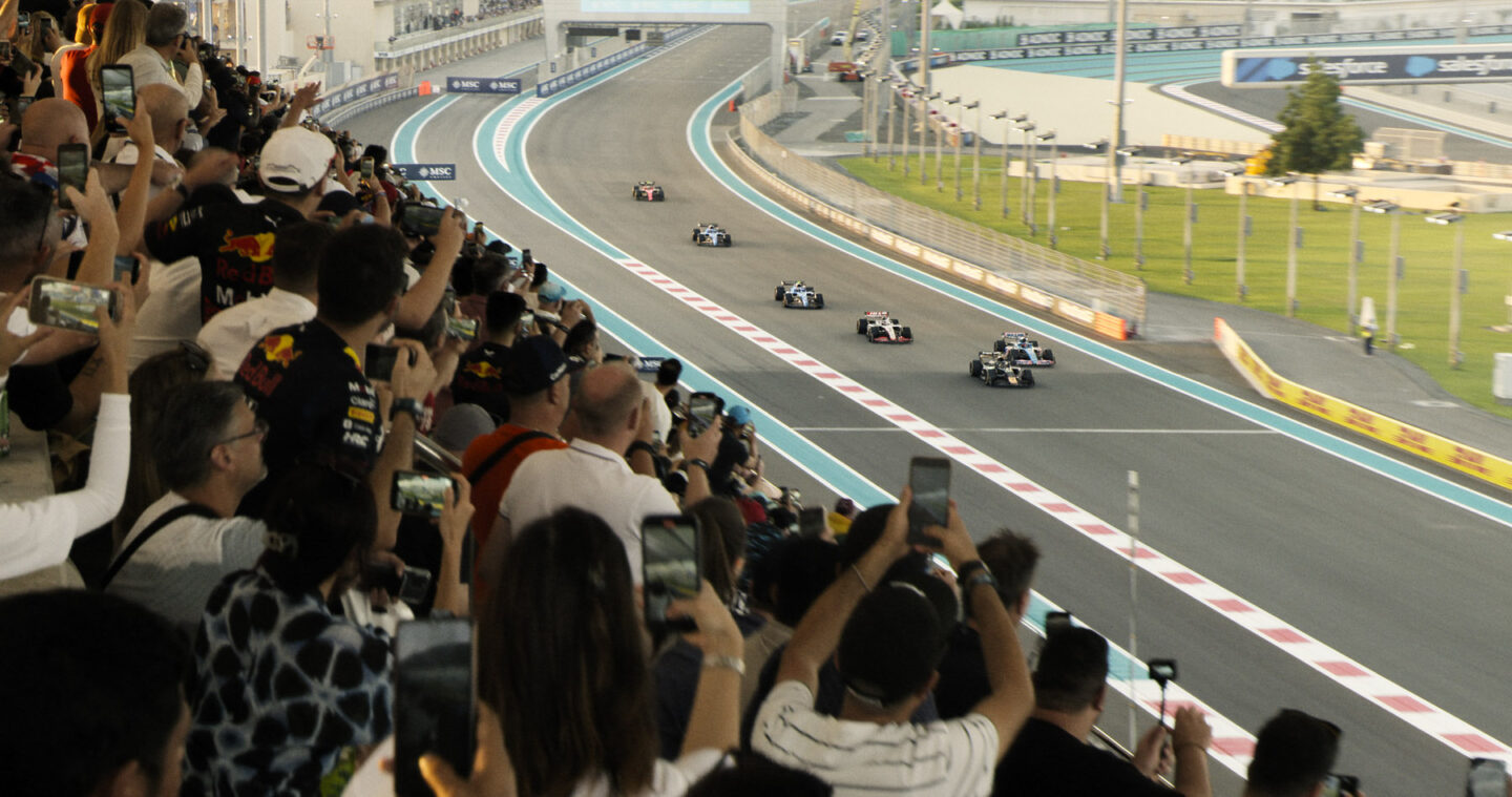 Scene from "F1: The Movie" in which racing fans watch cars on the track.