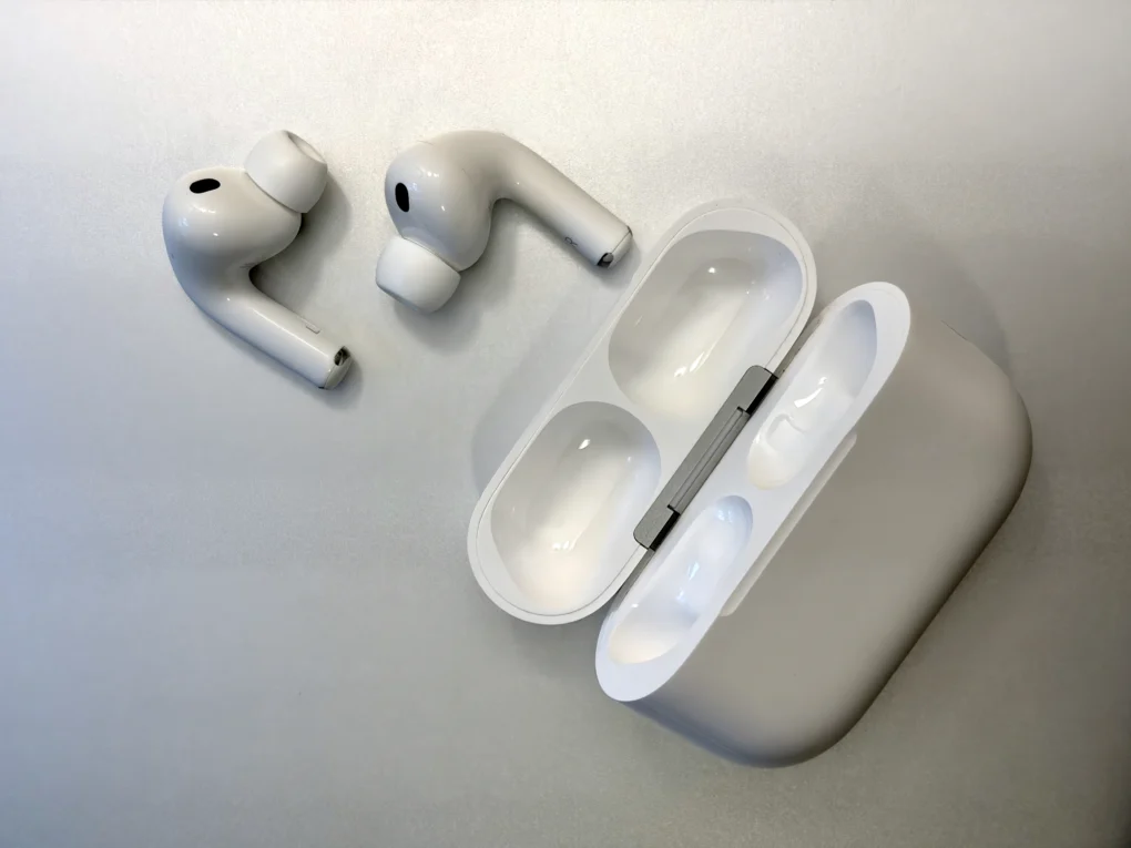 AirPods Pro 3 and their charging case on a silver aluminum background