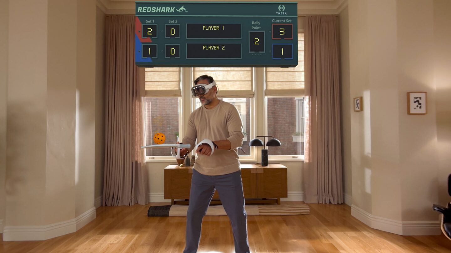 A man wearing a Vision Pro and two Playstation VR2 Sense controllers, playing some kind of tennis game.