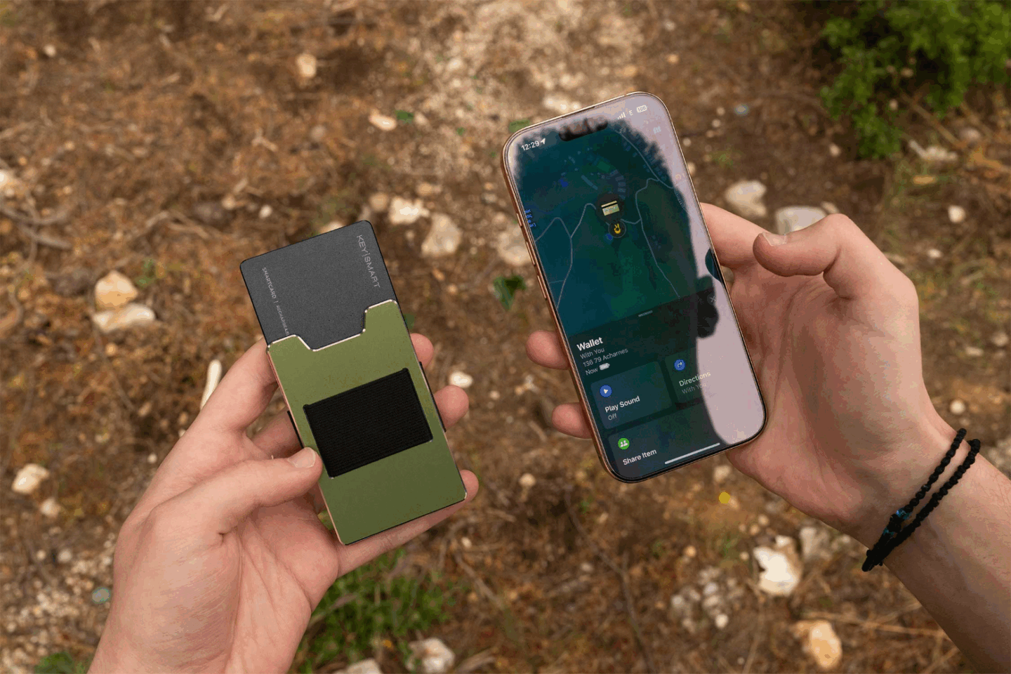 Photo of a man tracking his KeySmart SmartCard Lite using the Find My app on his iPhone while in the woods.