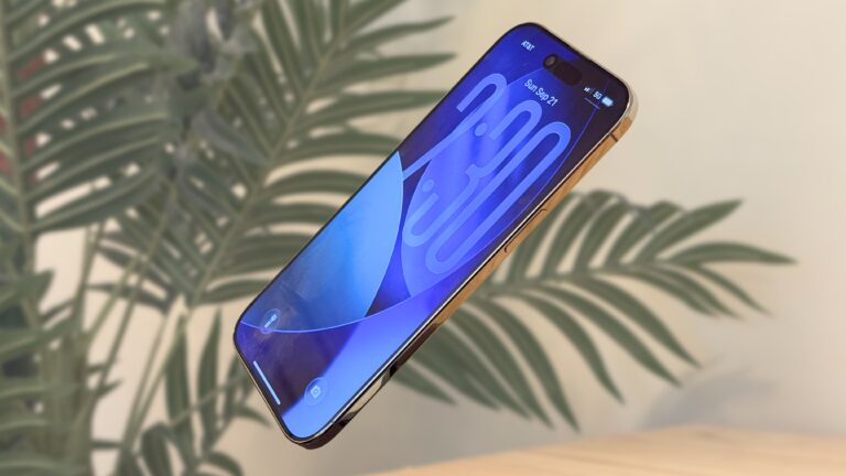 iPhone Air floating in front of a fake palm tree in a beige room