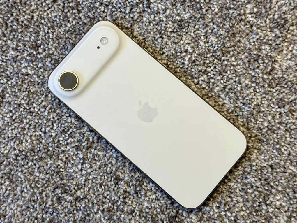 iPhone Air rear sitting on a speckled gray carpet.