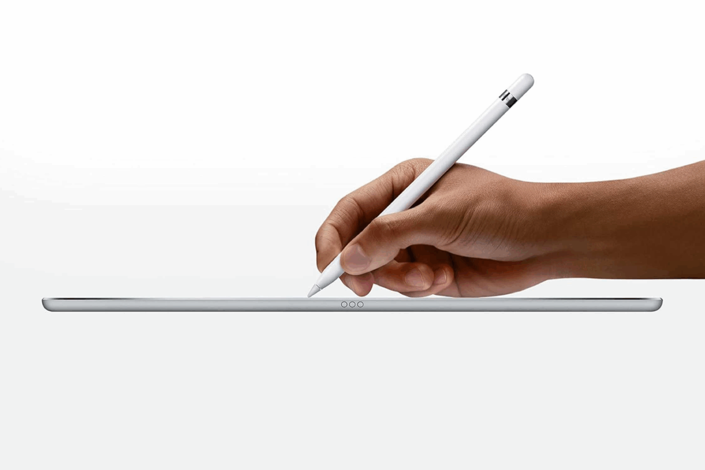 Close-up photo of a person's hand holding a refurbished Apple Pencil above an iPad