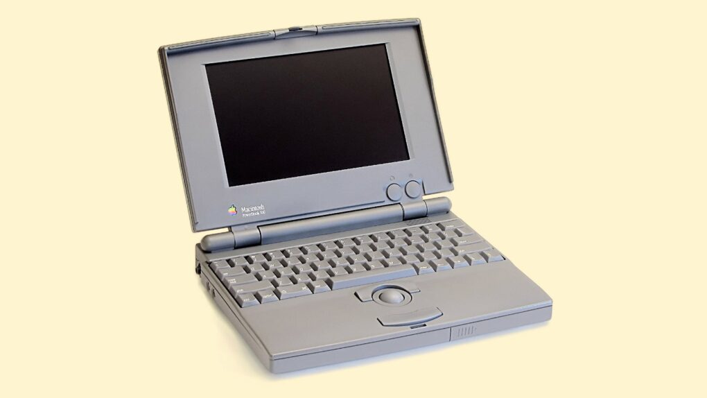 Photo of a Macintosh PowerBook 100 laptop on a cream-colored background