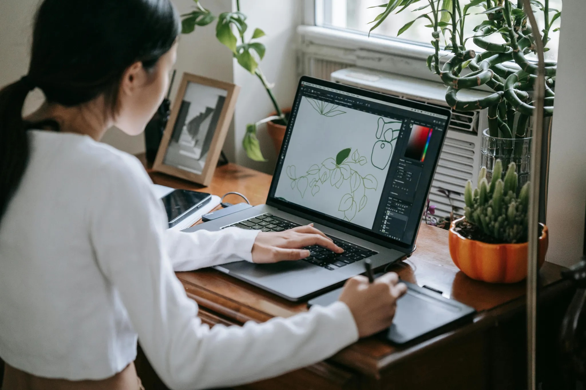 Woman using MacBook Pro Photo of a woman using a MacBook Pro with a stylus and input device.