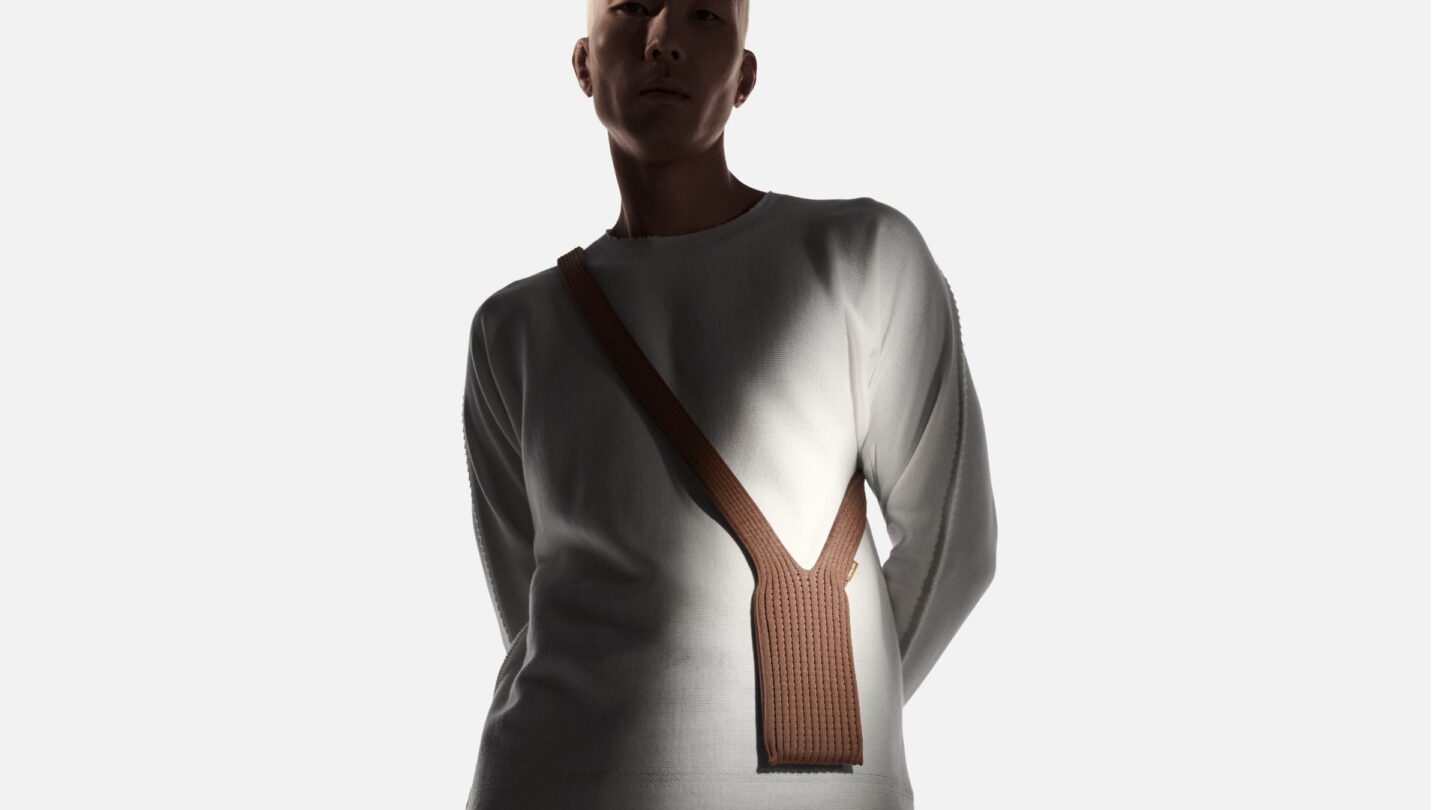 Photo of a brown iPhone Pocket worn crossbody-style by a model.