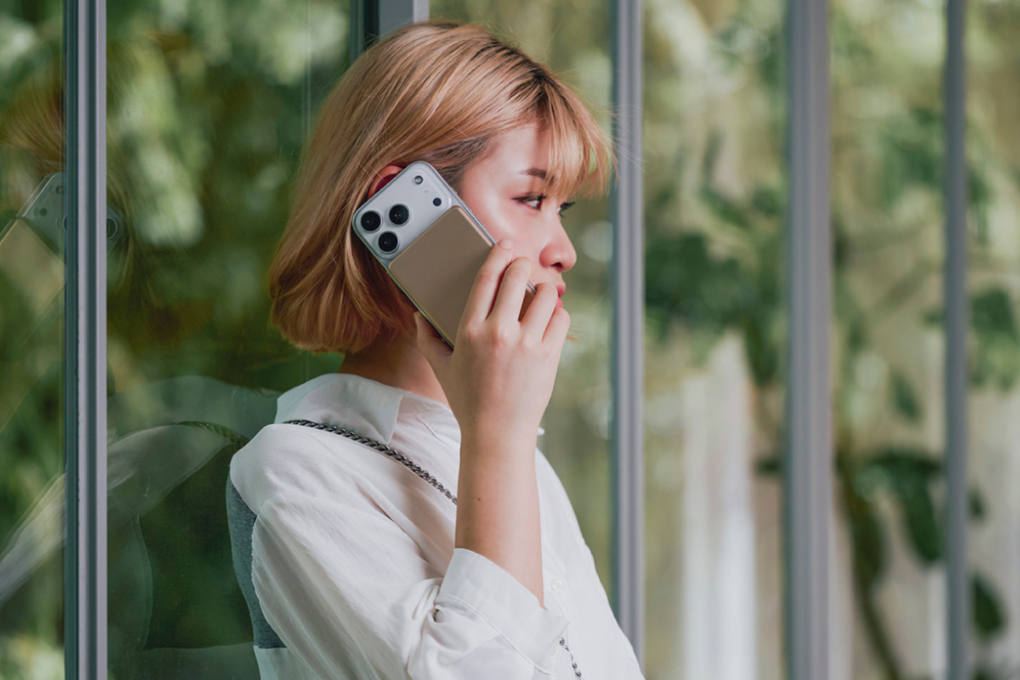 Woman on a call using iPhone 17 with a Vionta Q10 Qi2 battery pack on it