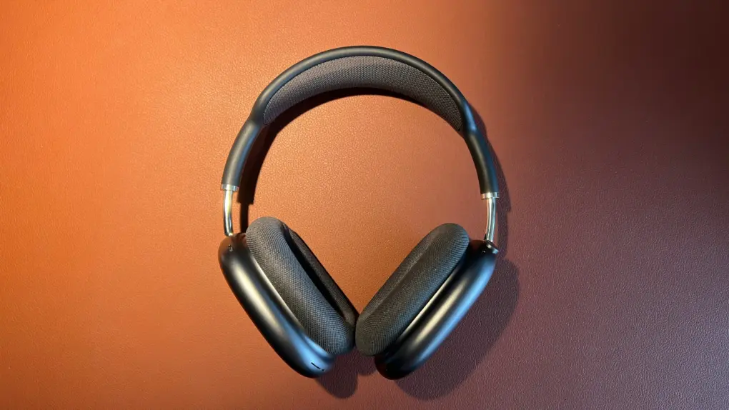 A photo of Apple's space gray AirPods Max headphones sitting on a leather mat
