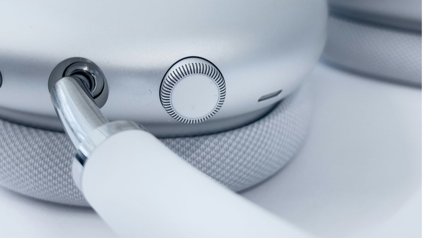 Close-up photo of white Apple AirPods Max headphones showing the headband and the unique Digital Crown
