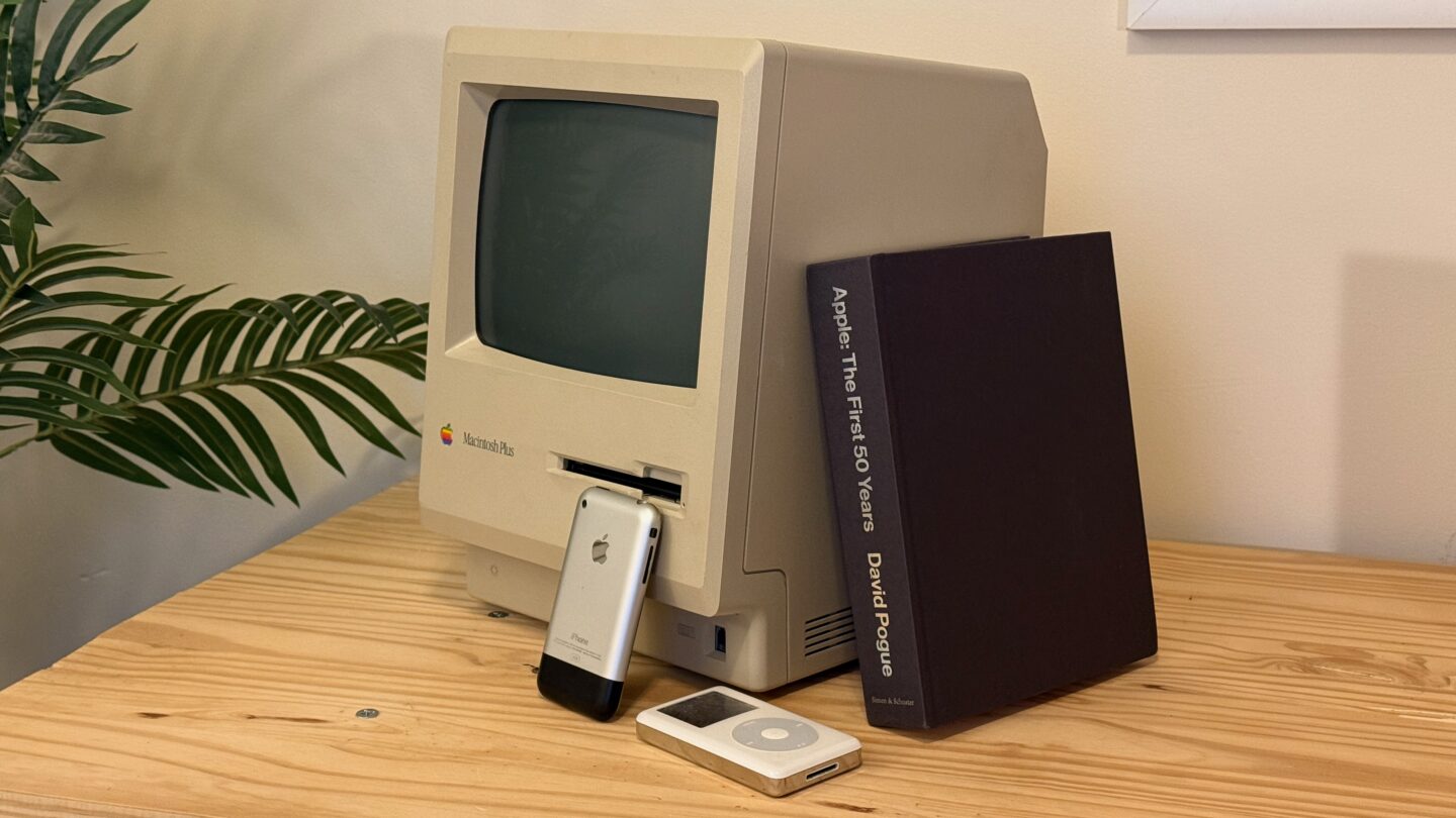 Apple First 50 Years Products 3 Apple: The First 50 Years book without the dust jacket, resting on a Macintosh Plus with an original iPhone and fourth-generation iPod