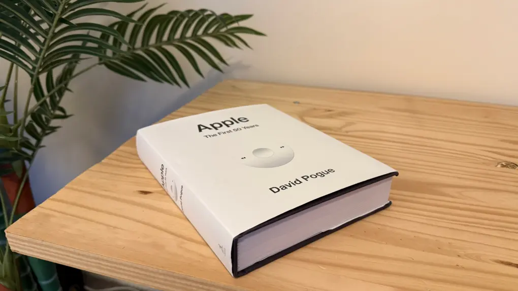 Apple: The First 50 Years book sitting on a pine table next to a fake tree