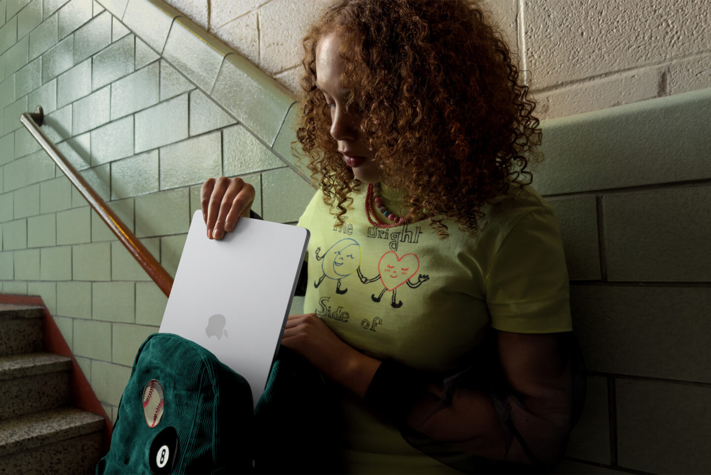 Student stowing the MacBook Air in a backpack in a school stairway