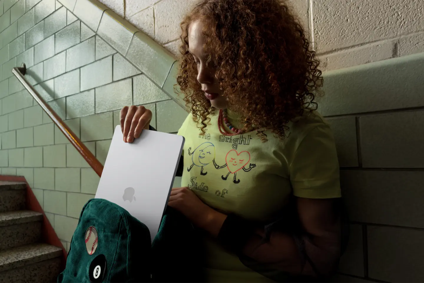 Student stowing the MacBook Air in a backpack in a school stairway