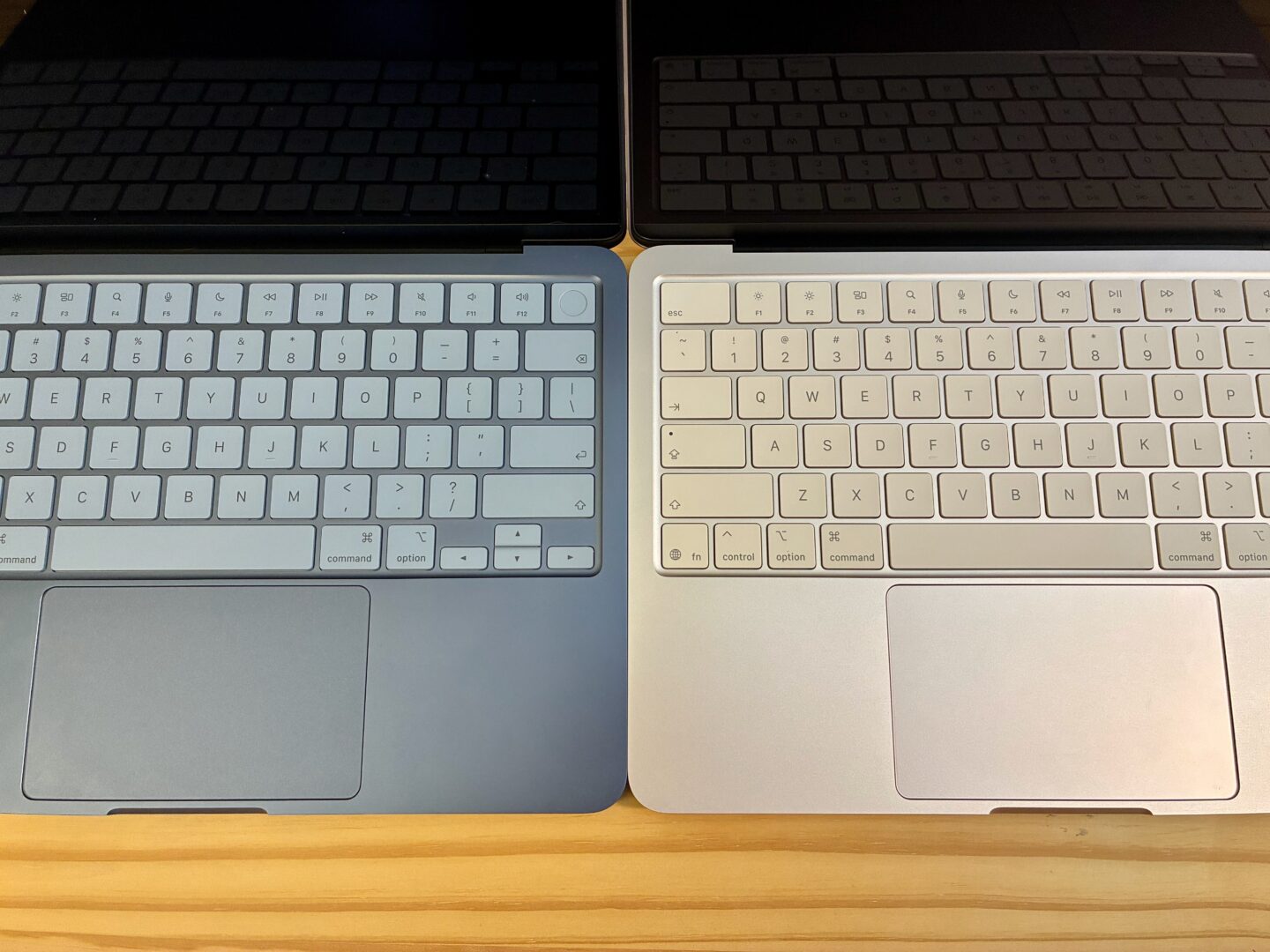 MacBook Neo in Indigo and Blush side by side showing the keyboard and trackpad