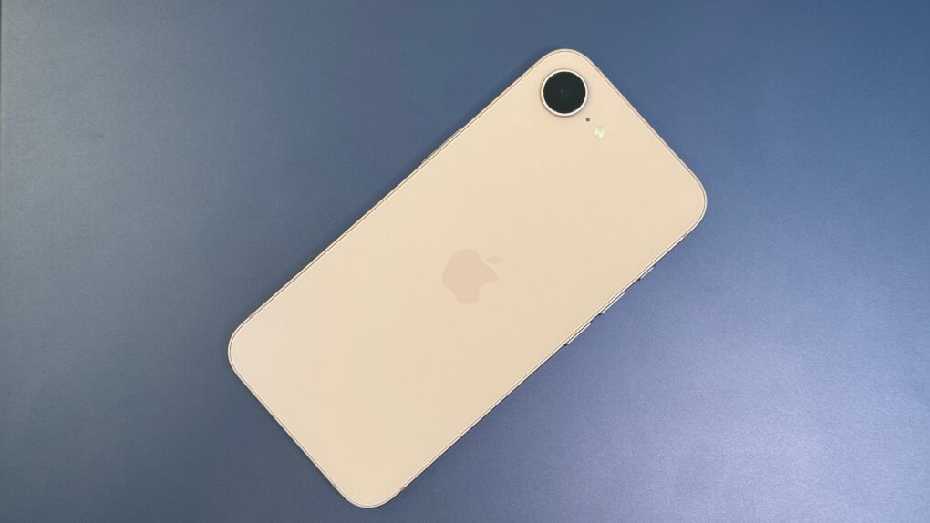 Pink iPhone 17e sitting on a blue shiny background