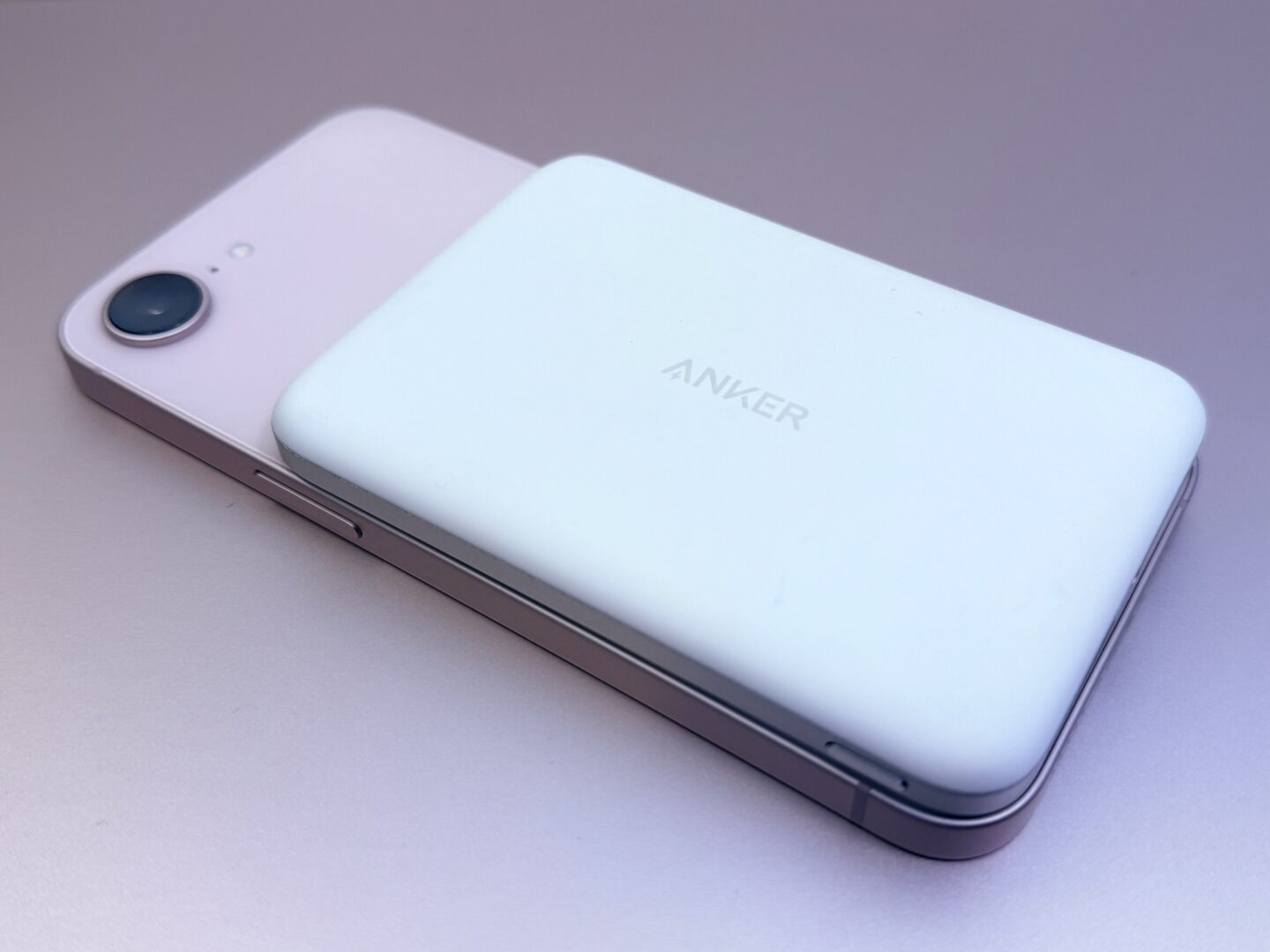 Pink iPhone 17e with a slim Anker MagGo battery on a pink background.