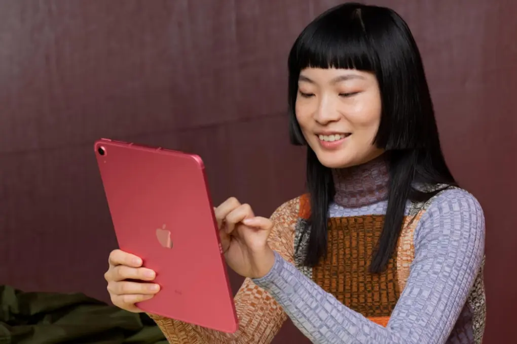 Photo of a smiling woman using a refurbished iPad 10.