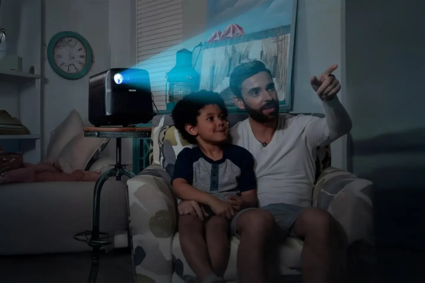 Father and son watching in the living room using an Ion Audio portable projector