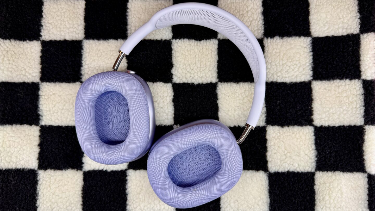 Purple AirPods Max 2 sitting on a black and white checkered background