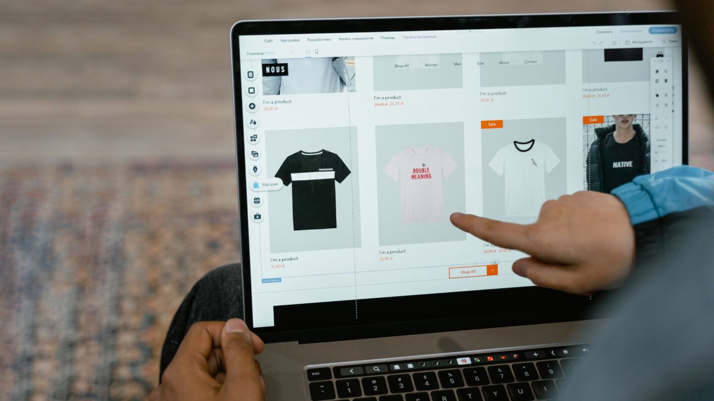Color photo of someone touching their MacBook screen to scroll a webpage