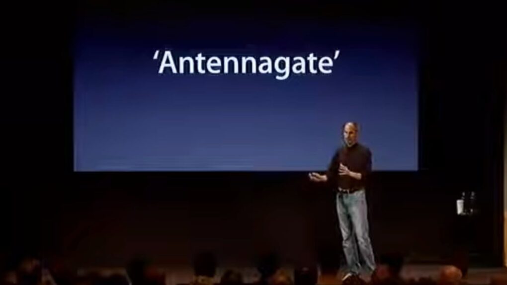 Steve Jobs stands onstage with the word 