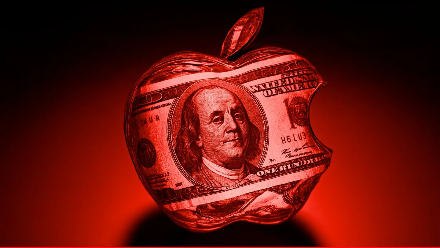 Red-tinted image showing Apple logo with $100 bill on it, used to illustrate story about Apple's $161 million quarterly loss in 1997