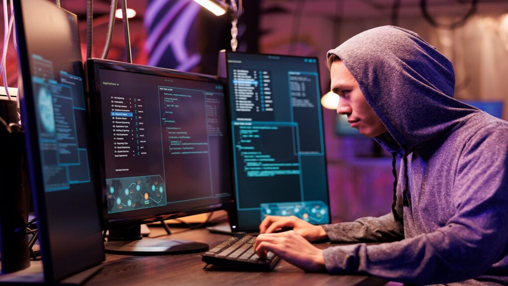 Man wearing a purple hoodie working on his desktop and studying with the The 2026 CompTIA Certification Training: Complete Exam Prep Bundle
