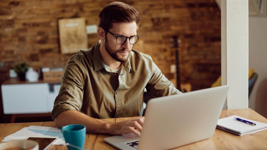 Man working on his laptop at a table, used to illustrate a a story about a deal on 1TB LifetimeCloud Secure Storage Lifetime Subscription