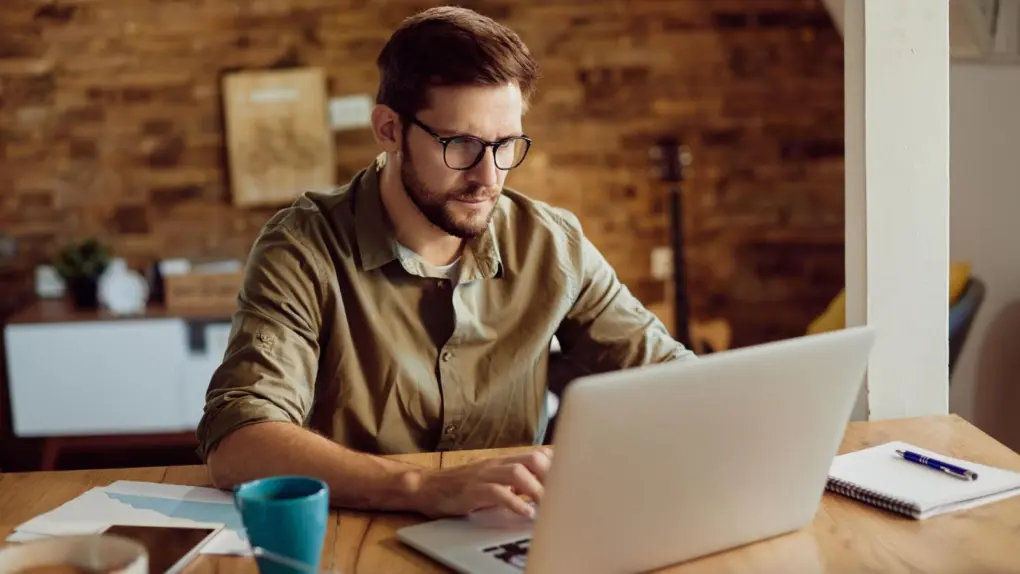 Man working on his laptop at a table, used to illustrate a a story about a deal on 1TB LifetimeCloud Secure Storage Lifetime Subscription