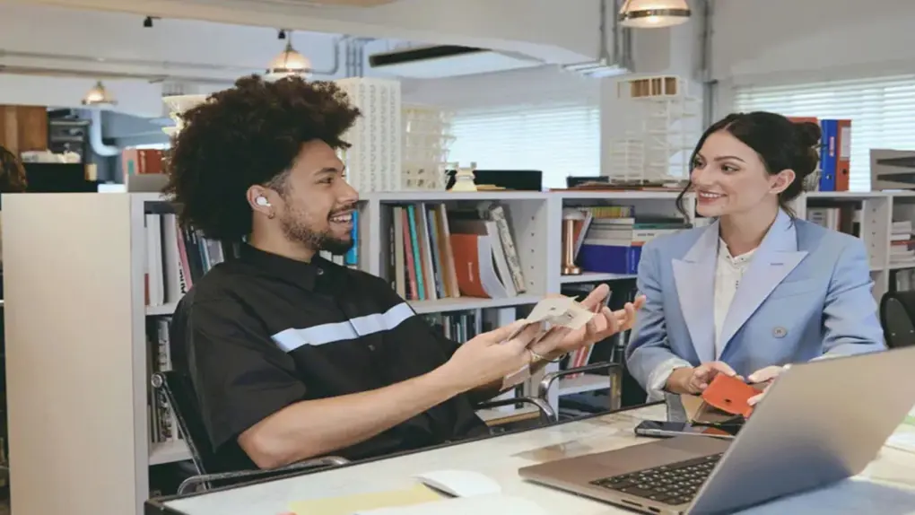 Man wearing Sony LinkBuds Open earbuds while talking to a female co-worker in their offfice